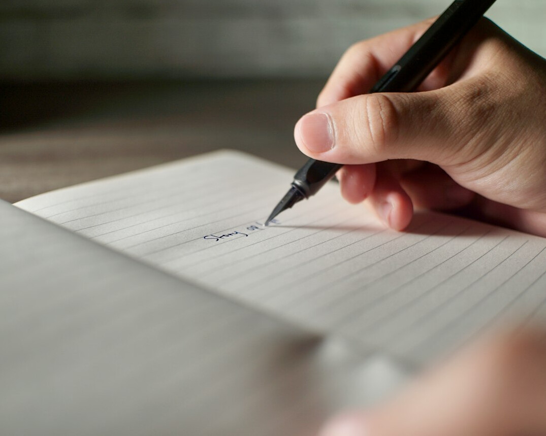 person writing in journal