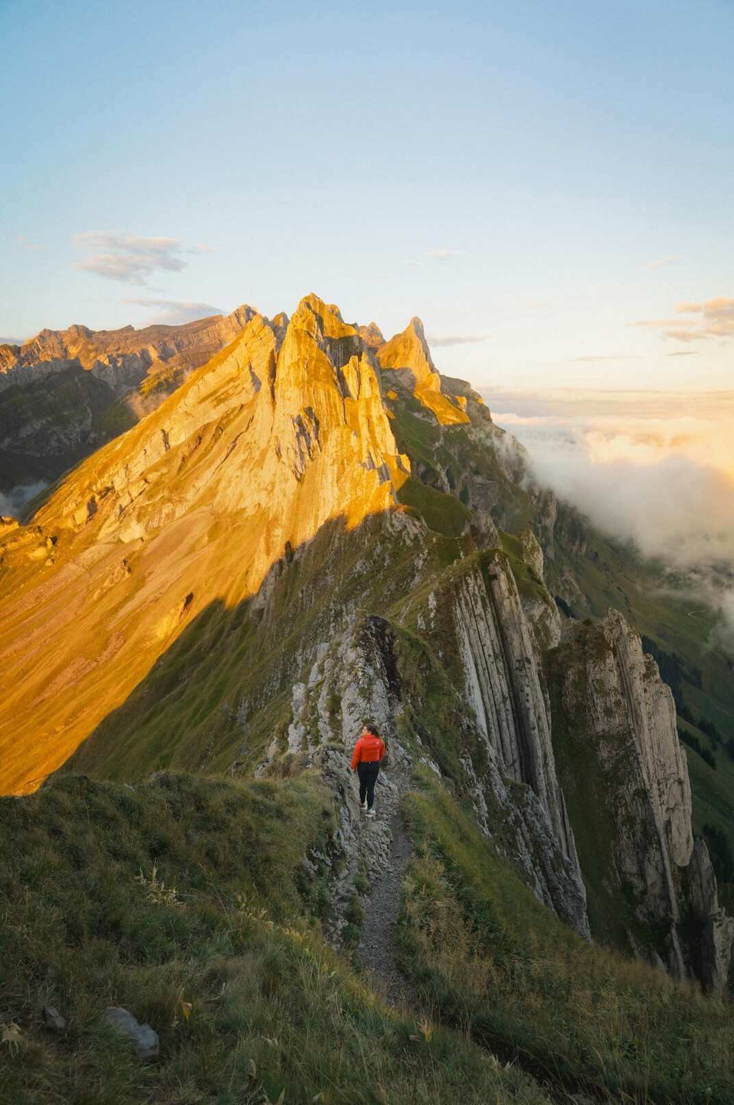 person climbing mountain at sunrise