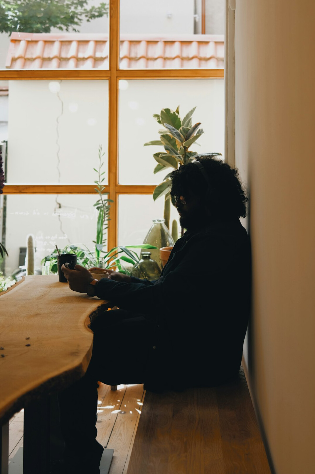 Person sitting by a window reflecting quietly with a notebook